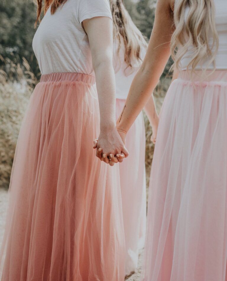 Photo of bridesmaids wearing pink skirts and white tops