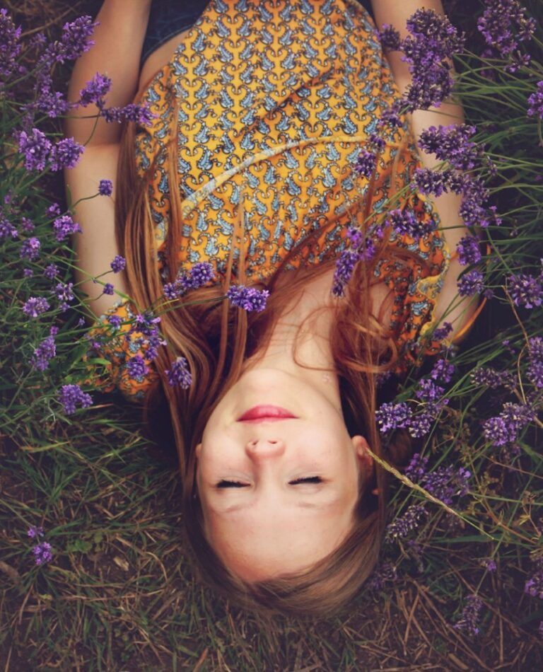 Photo of a woman lying in a field of purple flowers